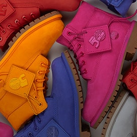 Timberland boots on the floor neatly arranged in multiple colors like orange, pink, purple and red.