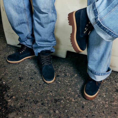 Man and Woman wearing Navy Blue Timberland Boots and jeans in street.