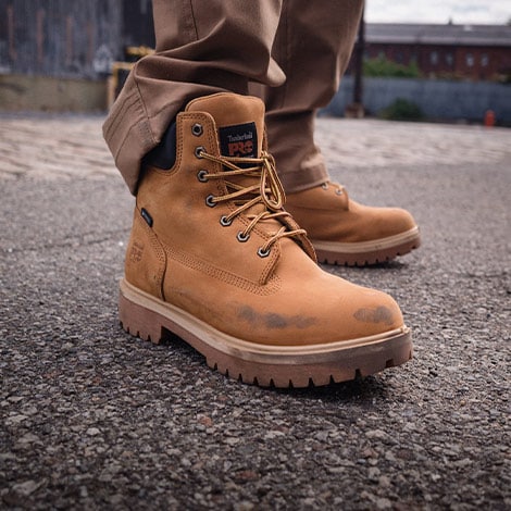 Person wearing Timberland PRO workwear boots in street setting.