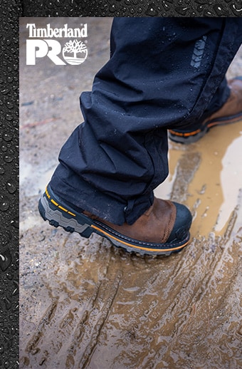 Image of a man wearing Timberland PRO Boondock boots stepping in the mud