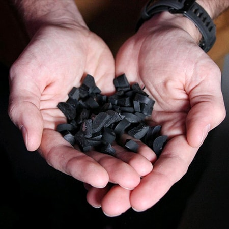 image of a mans hands holding a pile of rubber pellets