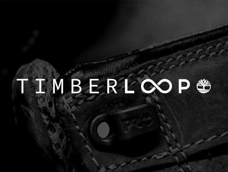 Closeup image of a black and white Timberland boot with the Timberloop logo on top